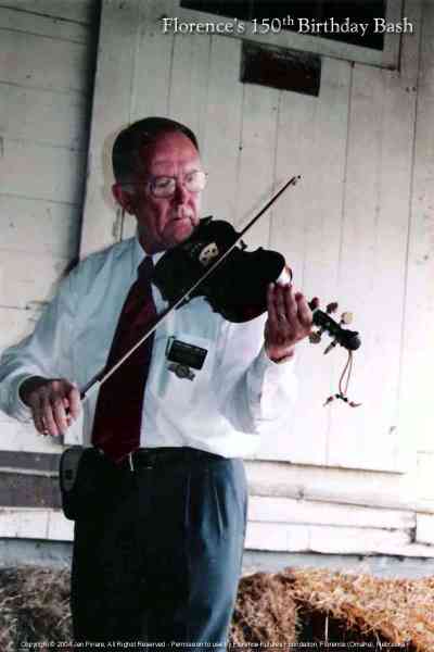 Elder Thurber plays fiddle at the Florence Mill.